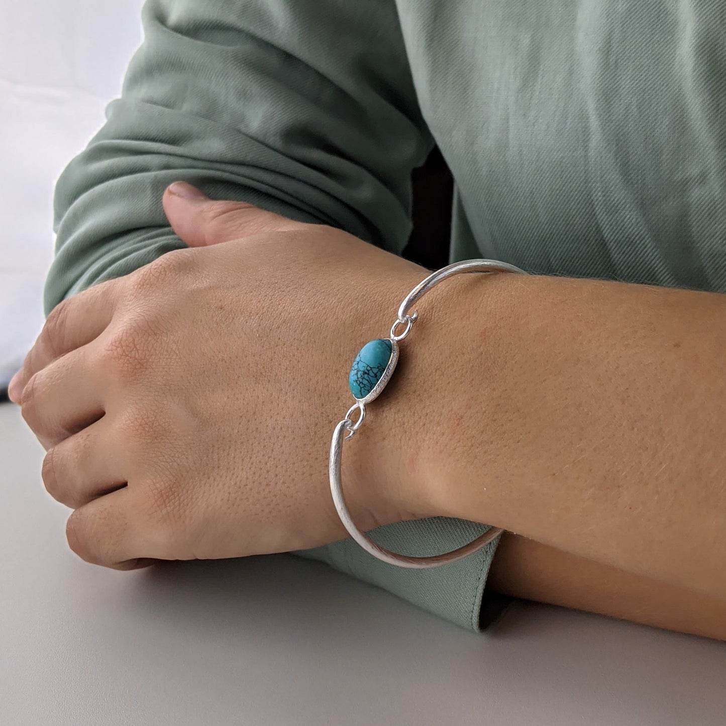 
                  
                    Sterling Silver Brushed Oval Turquoise Thin Bangle With Hook Clasp
                  
                